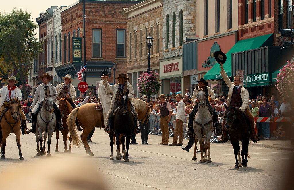 Small group of men on horseback in middle of street for Defeat of Jesse James Days