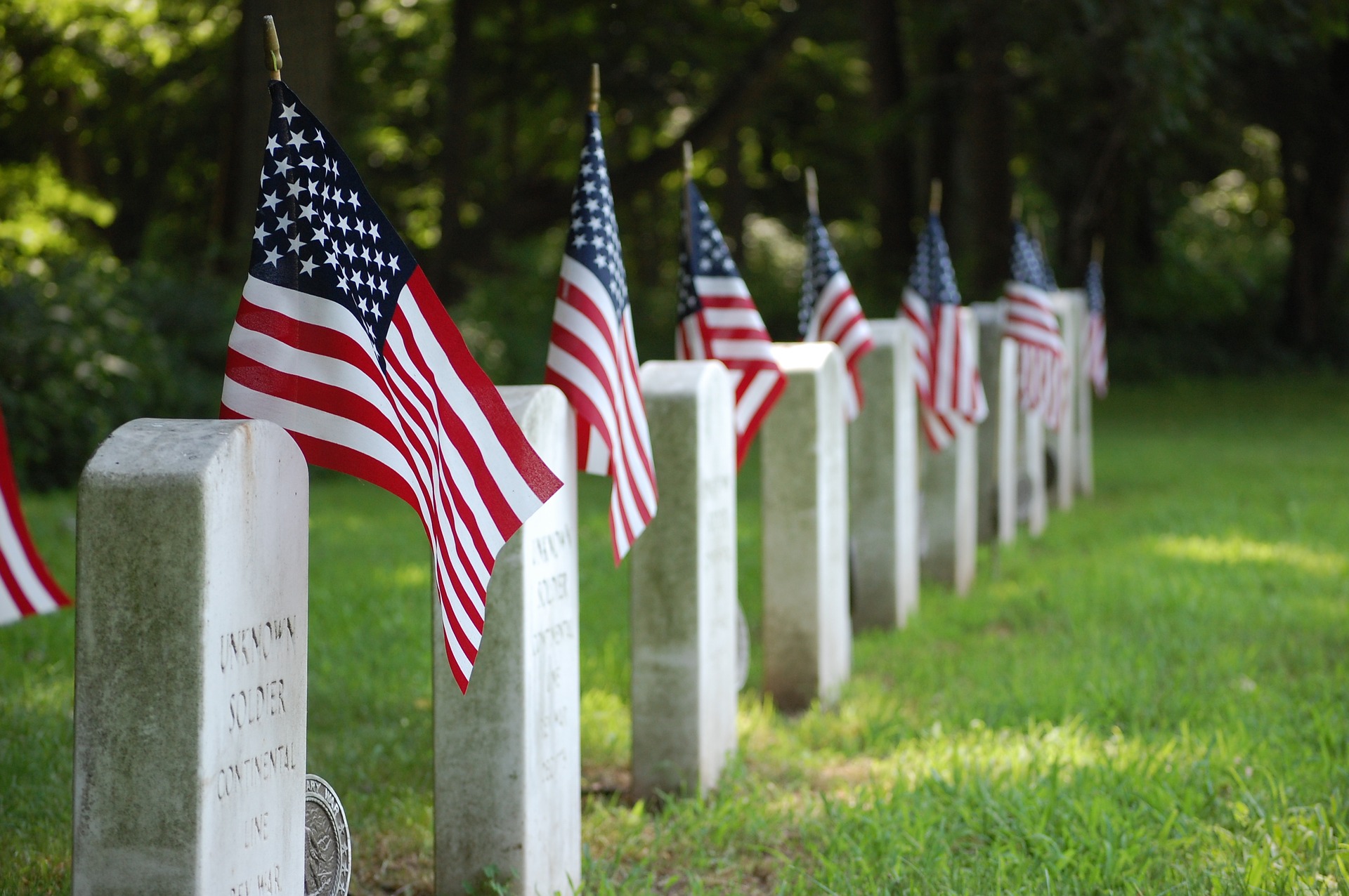 Military cemetery upright headstones with US flags